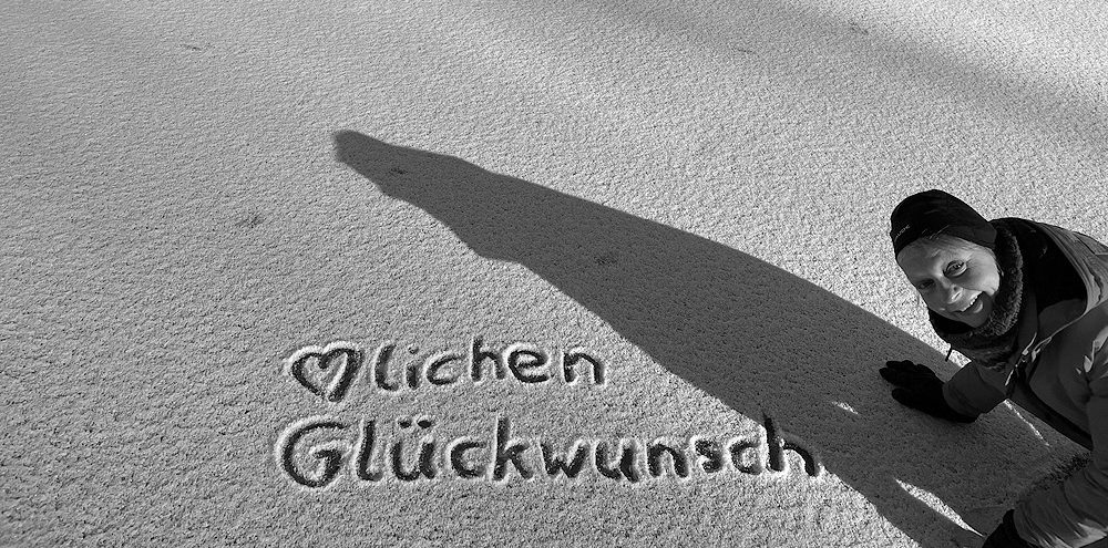 Christine Ullmann im Schnee mit Schrift "Herzlichen Glückwunsch"
